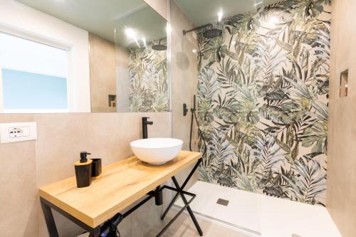 La salle de bains est pourvue d'un lavabo et d'une douche. dans l'établissement Molo Brin Rooms & Suites, à Olbia