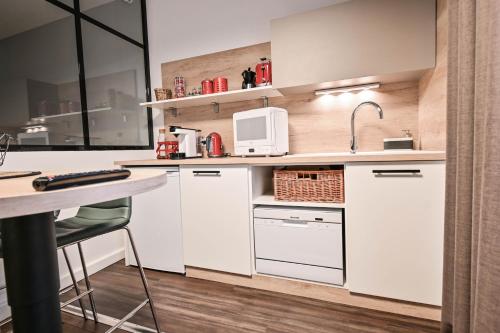 a kitchen with white cabinets and a counter top at Les cles du 27 Paris in Paris