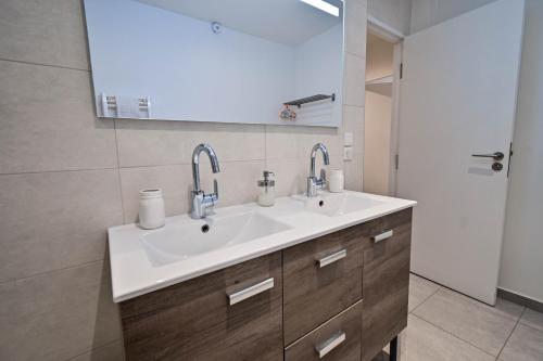 a bathroom with a sink and two faucets at Les cles du 27 Paris in Paris