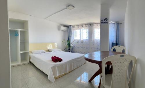 a small bedroom with a bed and a table at Sun & Shine Holiday Resort in Flic-en-Flac
