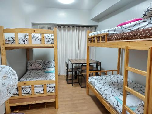 Habitación con 2 literas y mesa. en Bunked Bed Room Sharing, en Manila