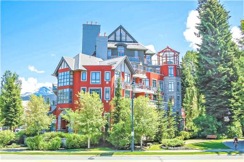 a large red building with trees in front of it at Alpenglow Lodge by Elevate Vacations in Whistler