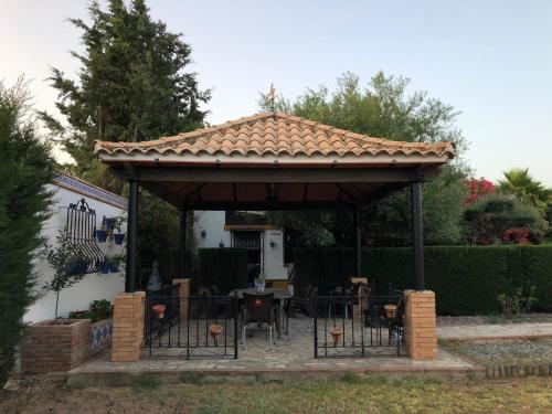 einen Pavillon mit Tischen und Stühlen darunter in der Unterkunft Casa Rural El Laure in Villamartín