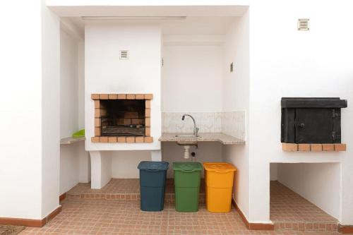 una cocina con 3 cubos de basura y un fregadero en Villa para 10 em Porches com piscina aquecida e ar condicionado, en Porches