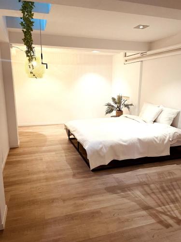 1 dormitorio con 1 cama blanca grande y suelo de madera en AIR BNBAR N°13, en Schaffhausen