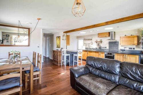 a living room with a couch and a table and a kitchen at The Lodge in the heart of Boscastle. in Boscastle