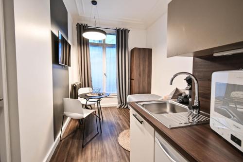 a kitchen with a sink and a counter top at Les cles du 27 Paris in Paris