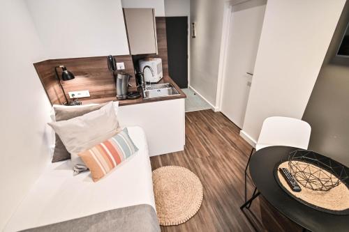 a small room with a couch and a table and a kitchen at Les cles du 27 Paris in Paris