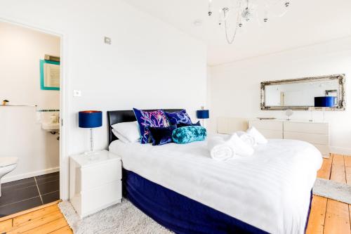 a white bedroom with a large bed with blue accents at Orla-Mo Victorian Captains House,St Ives,Cornwall,Sleeps10-15,Parking4cars,Refurb2022 in St Ives