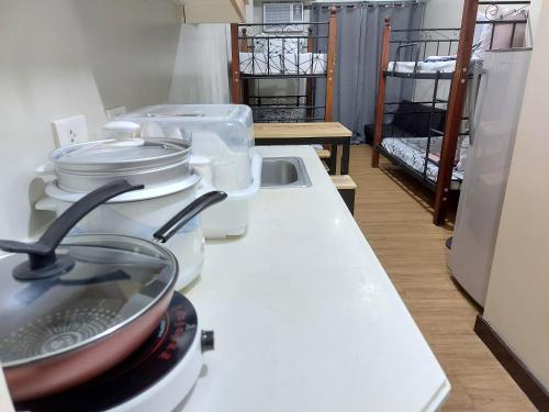 a kitchen with a counter top with pots and pans at Male Room Sharing in Manila
