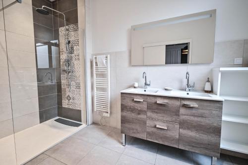 a bathroom with a sink and a shower and a mirror at Les cles du 27 Paris in Paris