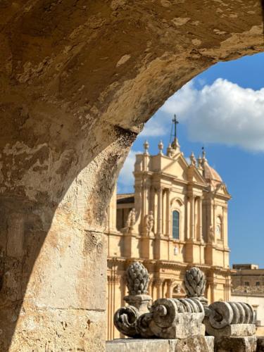 a building with a cross on top of it at Tannur Del Carmine in Noto