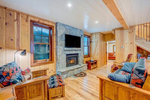 a living room with wooden walls and a stone fireplace at A Bear's Rest in Homewood