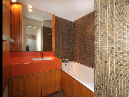 une salle de bain avec un lavabo, une baignoire et un miroir dans l'établissement Studio agréable Ski au pieds Balcon - FR-1-344-979, aux Menuires
