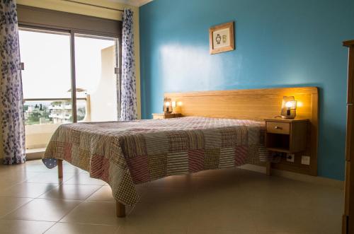a bedroom with a bed in a room with a window at Apartamentos Vista Mar in Armação de Pêra