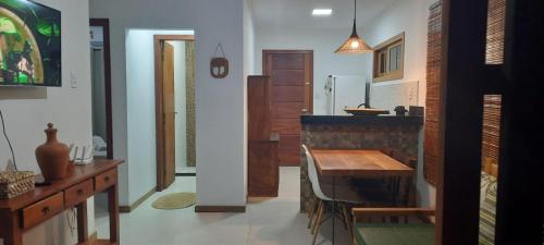eine Küche mit Holztisch und ein Esszimmer in der Unterkunft Vila Corumbau Cacau in Corumbau