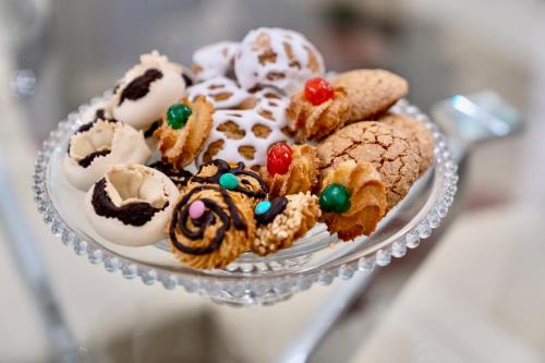 un plato de cristal con galletas y otros postres. en LA SUITE DE TURRITAN en Sassari