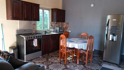 La cuisine est équipée d'une table, d'une cuisinière et d'un réfrigérateur. dans l'établissement Casa Victoria, à San Benito