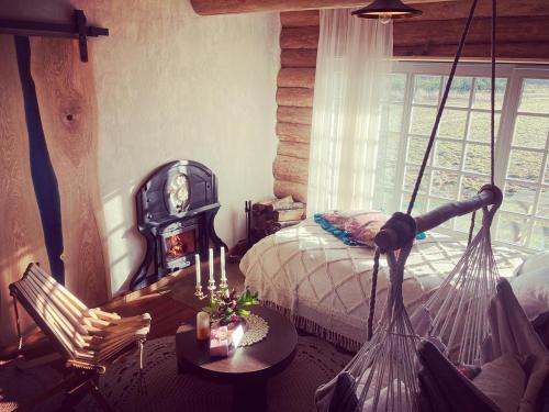 a bedroom with a bed and a table and a window at LODĒNU namiņš in Bauska