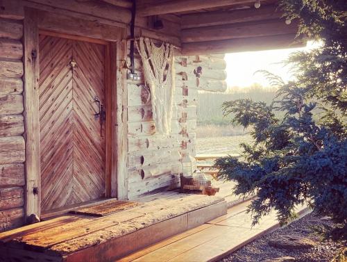 eine Holztür an der Seite eines Gebäudes in der Unterkunft LODĒNU pirtiņa in Bauska