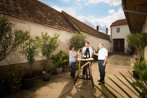 a group of people standing around a table in a courtyard at Weingut Krell in Mitterretzbach
