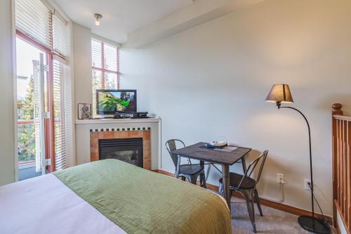 a bedroom with a bed and a table and a fireplace at Alpenglow Lodge by Elevate Vacations in Whistler