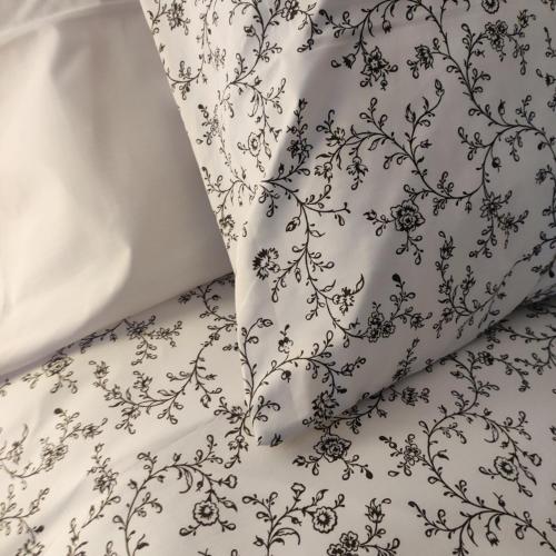 a white blanket with a black floral pattern on it at Pensión Mesón La Lonja - Herbers in Herbés