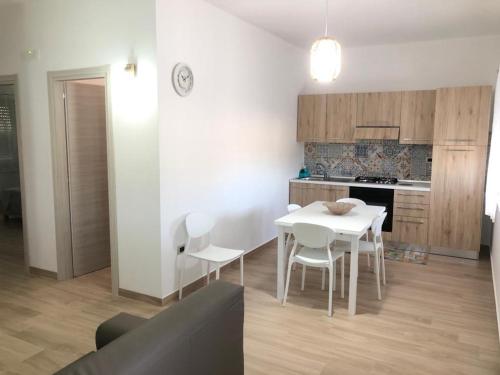 a kitchen with a white table and white chairs at ApartHotel Capo Rizzuto in Ovile la Marinella