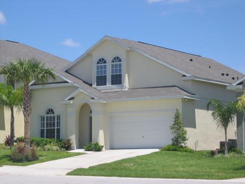 a house with palm trees in front of it at Luxury 5 Bedroom Villa with Secluded Pool/Spa in Glenbrook community near Orlando in Orlando