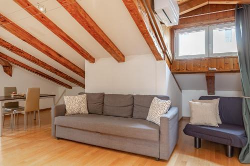 ein Wohnzimmer mit einem Sofa und einem Tisch in der Unterkunft Rifugio Hemingway, Trieste centro con parcheggio in Triest