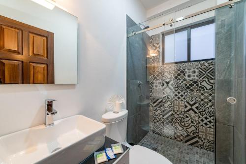 a bathroom with a shower and a sink and a toilet at Mi Querida Maribel Hotel in Santa Cruz Huatulco