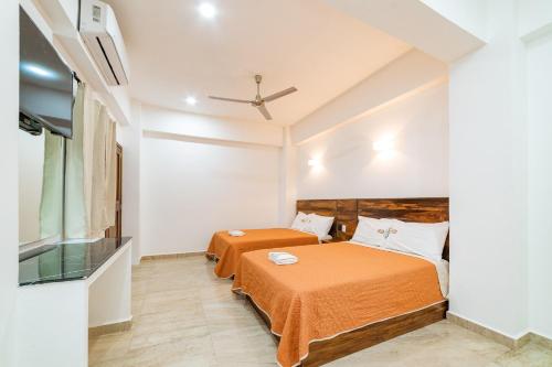 - une chambre avec 2 lits et un ventilateur de plafond dans l'établissement Mi Querida Maribel Hotel, à Santa Cruz Huatulco