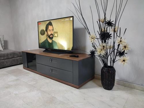 a tv sitting on a stand in a living room at LUXURY 3 bedroom apartment with pool, Nouaceur, Morocco in Derroua