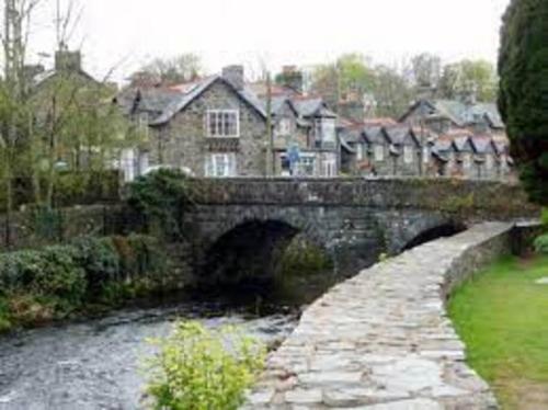 a stone bridge over a river in a village at Harlech/HUGE Three bedroom/BEST location in Llanbedr