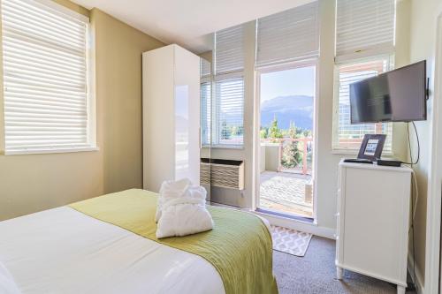 a bedroom with a bed and a tv and a window at Alpenglow Lodge by Elevate Vacations in Whistler
