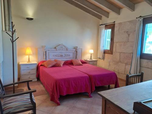 a bedroom with a large bed with a pink blanket at Casa Familiar y Acogedora in Sa Pobla