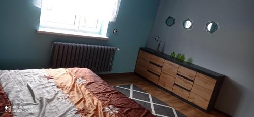 a bedroom with a bed and a dresser and a window at Apartament Szóstka nad Sołą in Czaniec