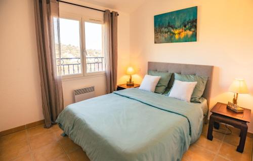 a bedroom with a large bed and a window at Bel appartement, terrasse, piscine, vue sur Golf in Sainte-Maxime