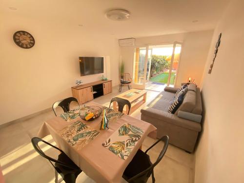 a living room with a table and a couch at Somptueux appartement rénové en bord de mer in Six-Fours-les-Plages