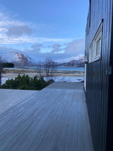 a wooden deck with a view of the snow covered mountains at Sand Beachhouse in Sand