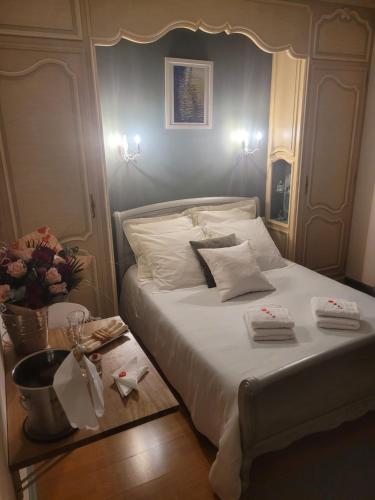 Un dormitorio con una gran cama blanca y una mesa en Ty Rosa, en Plougonven