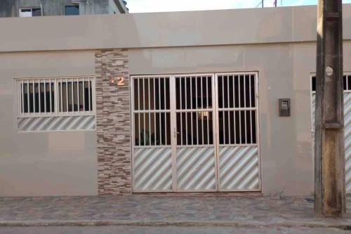 a white building with a large garage door at Seu lar em Bonito-PE in Bonito