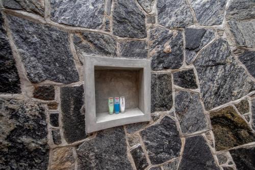 a niche in a stone wall with four toothbrushes at Tree of Life Resort in Bentota