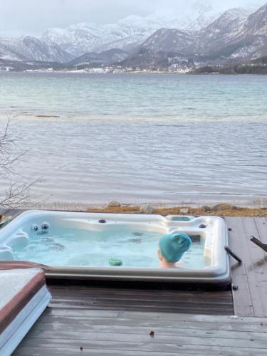 a hot tub on a dock next to a body of water at Sand Beachhouse in Sand