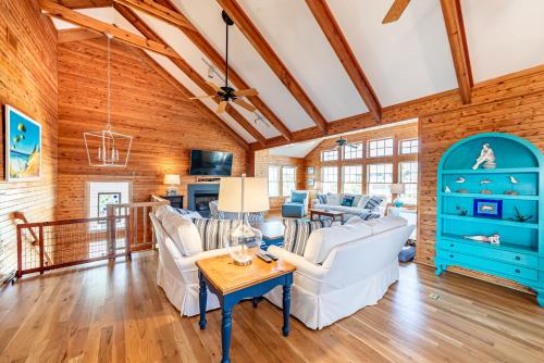 a living room with wooden walls and a wooden ceiling at Shore Enough in Sanderling