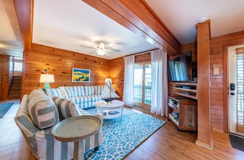 a living room with a couch and a tv at Shore Enough in Sanderling