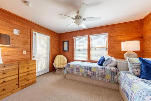a bedroom with two beds and a ceiling fan at Shore Enough in Sanderling