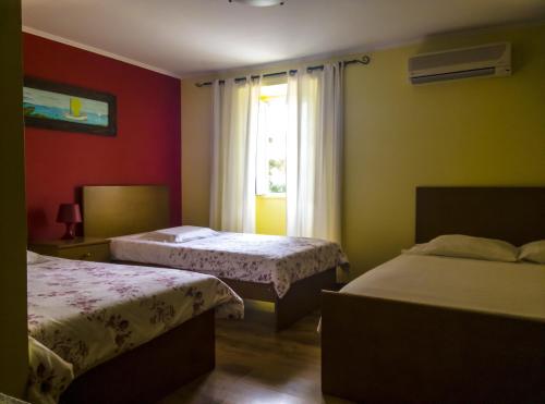 a hotel room with two beds and a window at Hotel O Catraio in Montijo