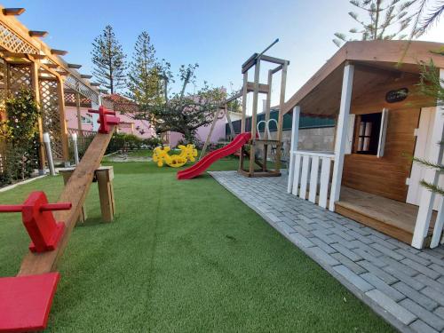 a playground with a slide and a play house at Casa dos Malmequeres in Sintra