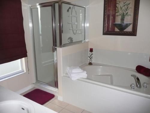 a bathroom with a shower and a tub and a sink at Luxury 5 Bedroom Villa with Secluded Pool/Spa in Glenbrook community near Orlando in Orlando